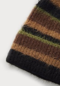 Bonnet tricoté avec des rayures alternées dans des teintes de noir, marron et vert. Un matériau texturé et duveteux ajoute de l'intérêt visuel et de la chaleur.