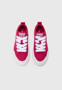 Baskets en toile rose avec semelles en caoutchouc blanc, présentant des lacets blancs et la marque "Converse All Star" sur la languette. Design à bout rond.