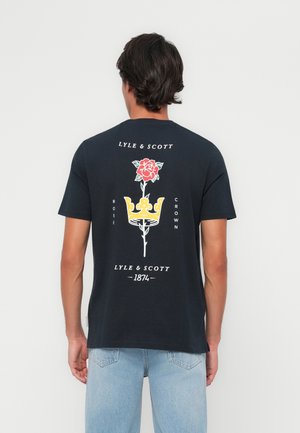 Crna pamučna majica s grafikom crvene ruže i žute krune na leđima, uz tekstualne elemente "Lyle & Scott" i "1874".