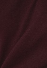 Burgunderfarbener Baumwollstoff mit glatter Textur und leichtem Stretch, der ein dezentes Rippenmuster aufweist.