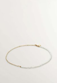 Collar de cadena de oro que presenta una fila de perlas blancas irregulares, combinando un acabado suave con un aspecto texturizado, ideal para superponer.
