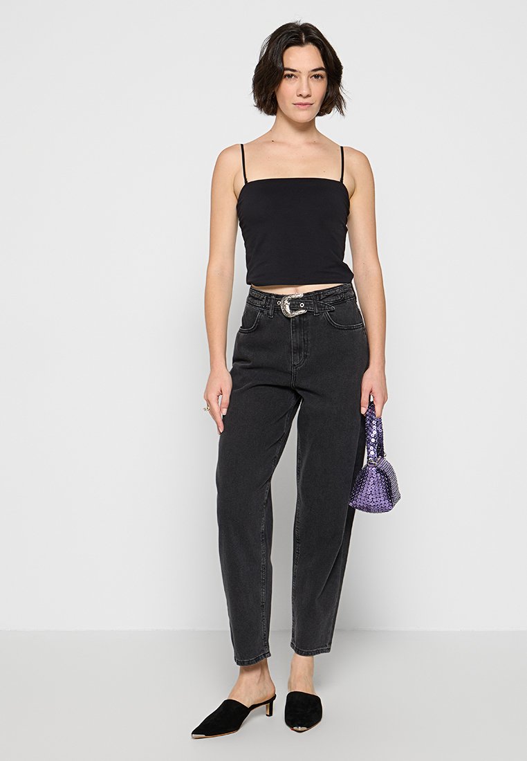 Top corto negro, pantalones vaqueros negros de cintura alta, mules negros de punta, bolso de lentejuelas moradas. Diseño simple, textura suave, ajuste a medida.