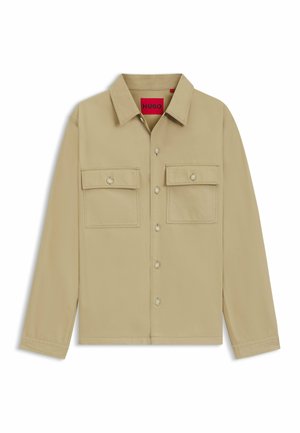 Beige button-up shirt with long sleeves, two chest pockets, and HUGO branding. Features a classic collar and smooth texture.