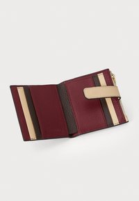 Compact wallet in burgundy leather with beige and dark brown accents. Features card slots and a zip compartment, textured finish.