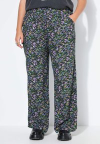 Zwarte bloemenbroek met een mix van paarse, gele en groene bloemen, voorzien van een elastische tailleband en zijzakken. Het materiaal is lichtgewicht.