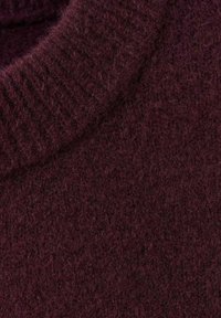 Maglione a maglia bordeaux con una consistenza morbida e pelosa e colletto a costine. Il tessuto appare caldo e spesso, adatto per il clima freddo.