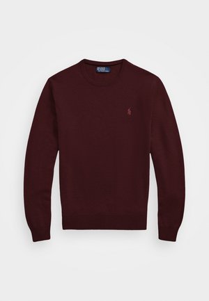 Suéter tricotado bordeaux com decote redondo, punhos e barra canelados, apresentando um pequeno logótipo bordado no peito. Textura suave.
