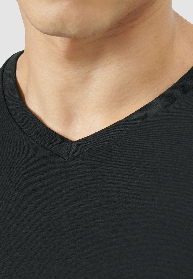 T-shirt nero a v con texture liscia e design aderente, caratterizzato da un collo cucito e senza motivi o dettagli visibili.