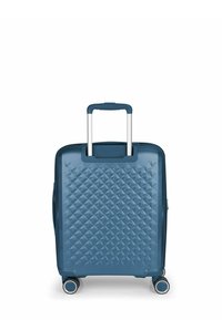 Maleta rígida azul con un patrón geométrico texturizado, mango retráctil y cuatro ruedas giratorias. Superficie suave y material duradero.