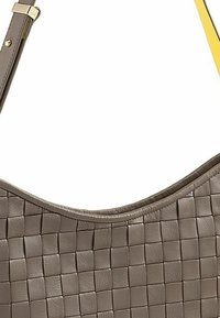 Bolso de hombro de cuero trenzado en gris apagado con parte superior curva, que presenta una textura suave y acentos en tono dorado.