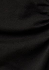 Nahaufnahme von glattem schwarzem Stoff mit subtilen Falten und Texturdetails.