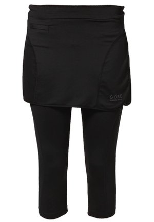 Mallas negras de tres cuartos para correr con una falda superpuesta, que incluye un pequeño bolsillo y el logo "GORE Running Wear" en la falda.