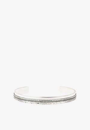 Bracelet manchette en argent avec une bande texturée de petits motifs rectangulaires et pointillés le long du centre. Design ouvert.