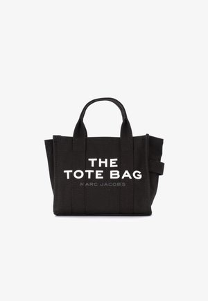 Saco tote de lona preto com alças duplas na parte superior, com texto branco a dizer "THE TOTE BAG" e "MARC JACOBS" na frente.