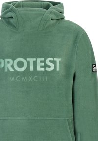 Felpa con cappuccio verde in pile, con tasca frontale, grande testo "PROTEST" e una piccola patch con logo sulla manica. Texture morbida e design con cappuccio.