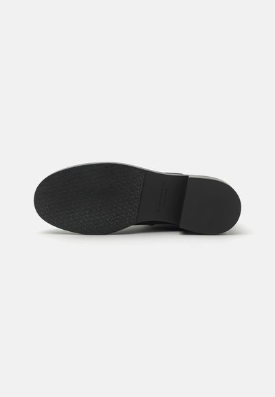 Zwarte schoenzool met een gestructureerd patroon, voorzien van een gladde rand en een iets verhoogde hak. Duurzaam rubbermateriaal.
