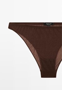 Brune bomulds-tanga undertøj med en glat tekstur, der har et enkelt design og en etiket med teksten "Massimo Dutti" nær linningen.