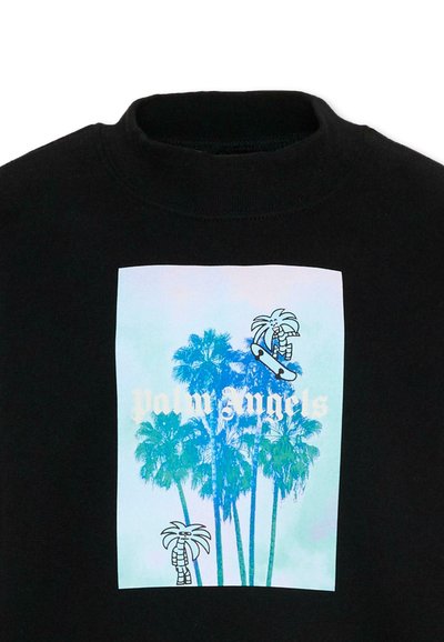 Chemise noire avec un graphique de palmier bleu, texte blanc "Palm Angels" et deux personnages de palmiers dessinés, dont un sur un skateboard.