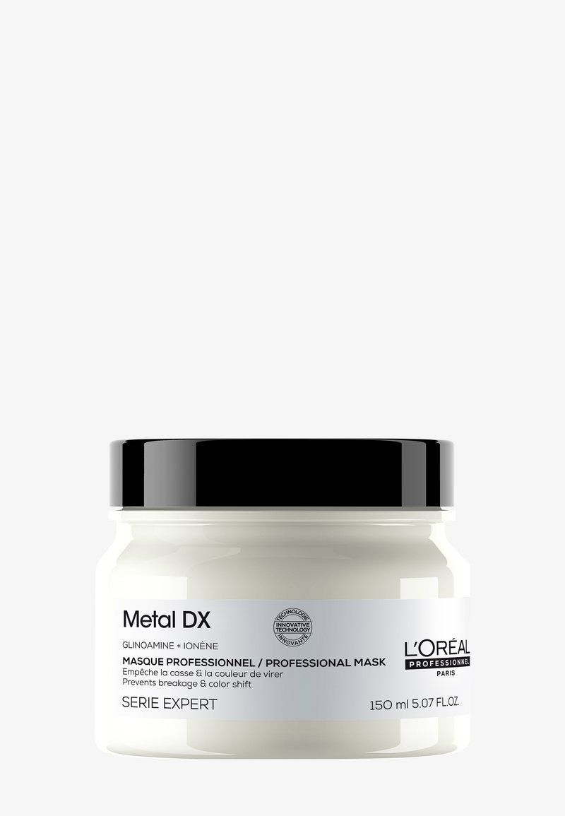 Vit glasburk med ett svart lock, märkt "Metal DX," innehållande 150 ml professionell hårmask. Slät yta, enkelt design, minimal branding.