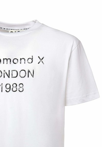 Camiseta blanca de algodón con texto impreso en negro: "Richmond X LONDON 1988" con una tipografía texturizada y desgastada. Mangas cortas, escote redondo.