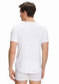 T-shirt bianco a maniche corte in cotone, con scollatura rotonda e una texture liscia, visto da dietro.