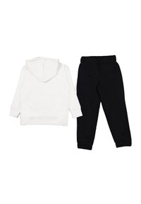 Felpa con cappuccio bianca a maniche lunghe abbinata a pantaloni della tuta neri con vita elastica e orli affusolati.