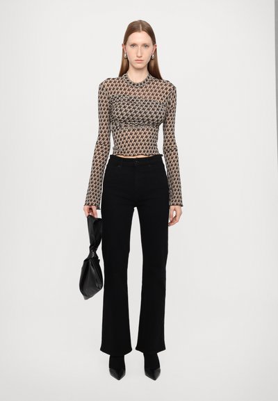 Langarm, figurbetontes Oberteil mit einem geometrischen Muster in Beige und Schwarz. Kombiniert mit hüfthohen, schwarzen Schlaghosen und einer schwarzen Tasche.