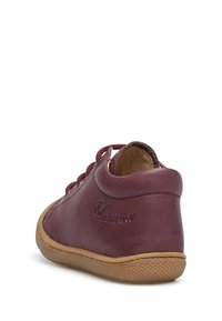 Scarpa di pelle borgogna con punta tonda, design con lacci e suola in gomma marrone. Presenta un logo in rilievo sul retro e una texture liscia.