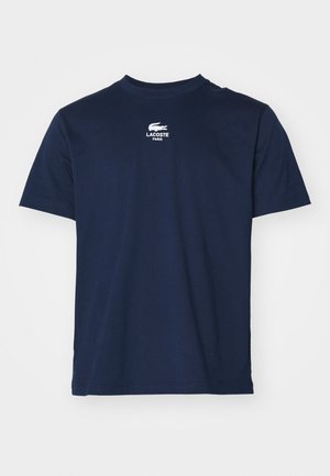 Navy blue cotton T-shirt with a round neck, short sleeves, and a white Lacoste logo printed on the chest. Soft, smooth texture.