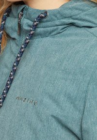 Giacca con cappuccio in tessuto verde petrolio con finitura testurizzata, cordini regolabili con motivo intrecciato e logo "MAZINE" ricamato.