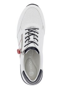 Baskets blanches avec un dessus perforé, accents noirs, fermeture à lacets et à zip, semelle intérieure grise, et un détail en rouge sur le côté.