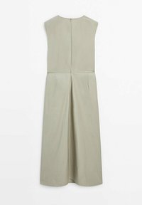 Robe midi sans manches de couleur beige clair avec fermeture éclair au dos et design plissé, présentée sur un fond blanc.