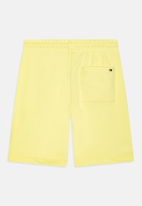 Gelbe Baumwollshorts mit elastischem Bund, ausgestattet mit einer Gesäßtasche und einem kleinen Logo-Highlight auf der Tasche.