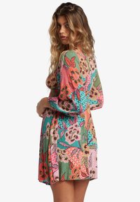 Bunt gemustertes Blumenkleid mit leuchtend pinken, grünen und orangen Mustern. Hergestellt aus strukturiertem Stoff mit puffigen Ärmeln und einem ausgestellt Rock.