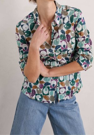 Kleurrijk button-up overhemd van lichtgewicht stof met een patroon van abstracte ovalen in tinten groen, paars, bruin en blauw, met opgerolde mouwen.