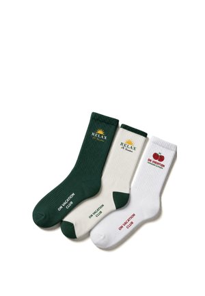 Three pairs of crew socks in green, cream, and white with "ON VACATION CLUB" text and sun or tomato designs on a white background.