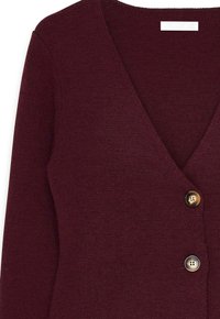 Bordowy dzianinowy kardigan z dekoltem w kształcie litery V, z dwoma złotymi guzikami i miękkim, teksturowanym wykończeniem. Długie rękawy i dopasowany fason.