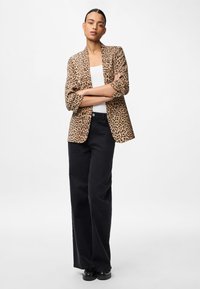 Μπεζ σακάκι με λεοπάρ σχέδιο από ελαφρύ ύφασμα, με χαλαρή γραμμή και ανοιχτό μπροστινό μέρος. Συνδυασμένο με ψηλόμεσες μαύρες παντελόνες σε φαρδιά γραμμή.