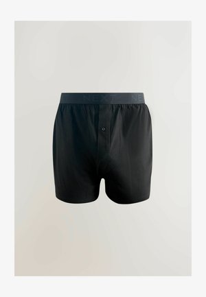 Juodos medvilnės bokseriai su elastinga NEXT prekės ženklo juosta, pasižymintys vieno mygtuko užsegimu ir glotnia tekstūra.