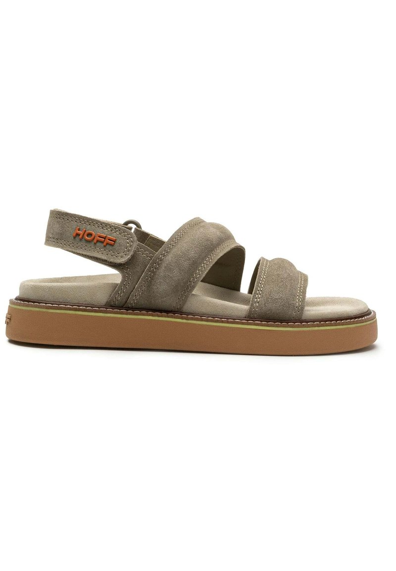 Suède sandalen in lichtbruin met twee brede banden, een hielband en een gevoerde binnenzool. Beschikt over een oranje logo en een rubberen loopzool.