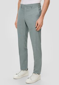 Lichtgrijze op maat gemaakte broek met een gestructureerde afwerking, recht model en riemlussen, gecombineerd met witte sneakers.