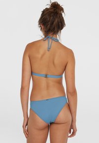 Blå bikiniuppsättning i mjukt tyg. Halterneck-design med justerbar knytning och spänne på baksidan. Sömlösa kanter.