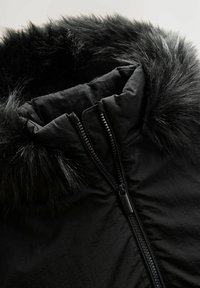 Schwarze gepolsterte Jacke mit einer Kapuze aus Kunstfell, Reißverschluss und strapazierfähigem Stoff. Die Kapuze hat ein voluminöses, weiches Aussehen.