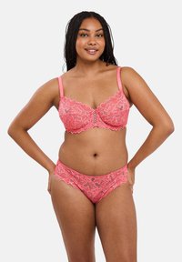 Koraalvormige kantbeha en bijpassende slips met bloemmotieven, golvende randen, verstelbare bandjes en een ademende textuur.