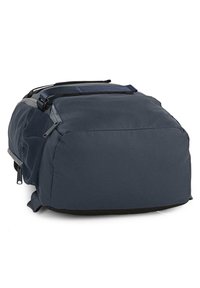 Mochila azul marino de forma redondeada, fabricada con tejido duradero. Cuenta con bolsillos laterales de malla y correas ajustables para un transporte seguro.