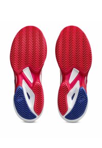 Scarpe sportive con una suola in gomma rossa e blu moldata, caratterizzata da un motivo a zig-zag, parte superiore in rete bianca e distintivi fori di ventilazione.