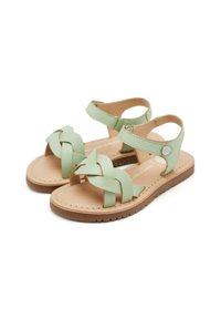 Sandali in pelle intrecciata verde con cinturino alla caviglia, design open-toe, suola marrone chiaro e dettaglio in metallo argento circolare.