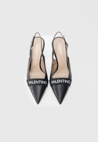 Czarne skórzane sandały na obcasie typu slingback z szpiczastymi noskami, wyposażone w szeroki czarny pasek z białym napisem "VALENTINO". Gładka faktura, minimalistyczny design.