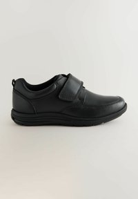 Chaussure en cuir noir avec un bout arrondi et une semelle en caoutchouc flexible. Présente une sangle Velcro sur le coup de pied pour un ajustement facile.