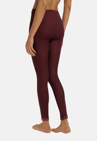 Bordeaux ribbelleggings hebben een hoge taille en kantafwerking bij de enkels. De stof ziet er zacht uit met een gestructureerde afwerking.